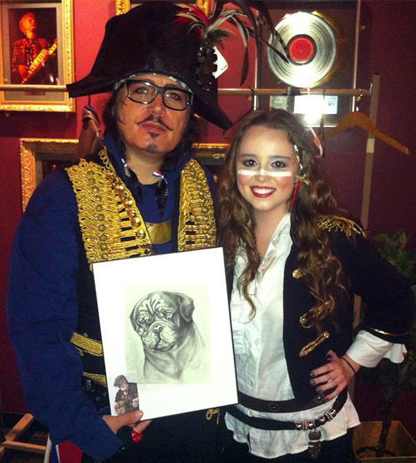 Adam Ant, singer of Adam and The Ants, with Artist Chelsea Smith holding her original pencil pet portrait she did of his pet dog.